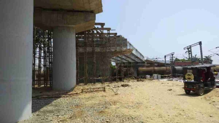 Ramnagar Overbridge, with workers and cranes in the frame.
